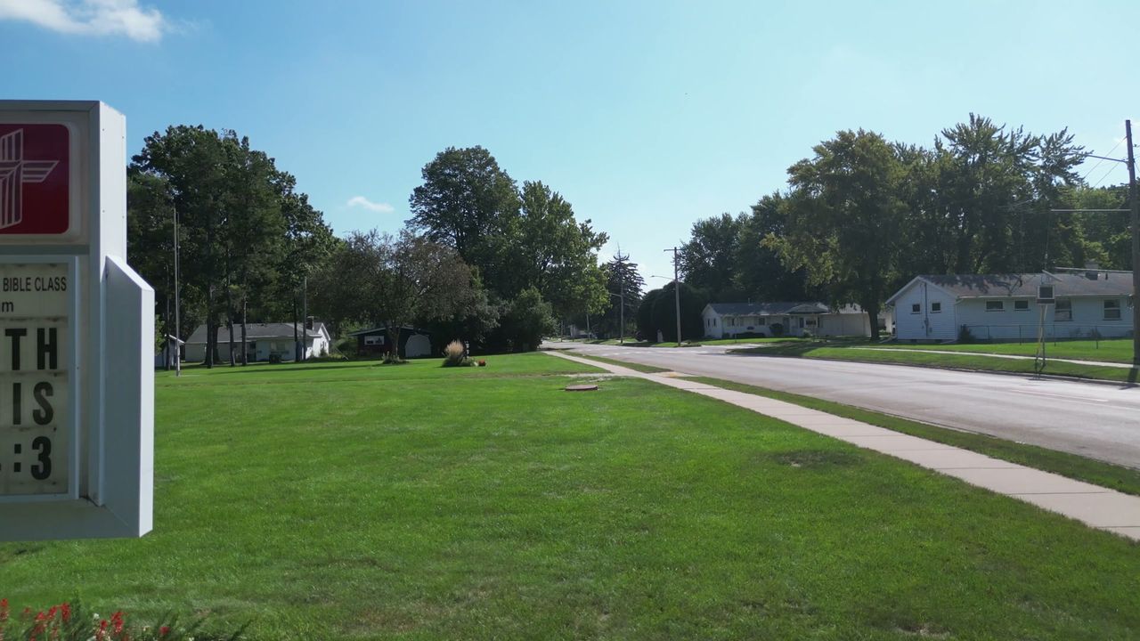 Wide view across the front of the St. Paul campus toward the buildings and trees.