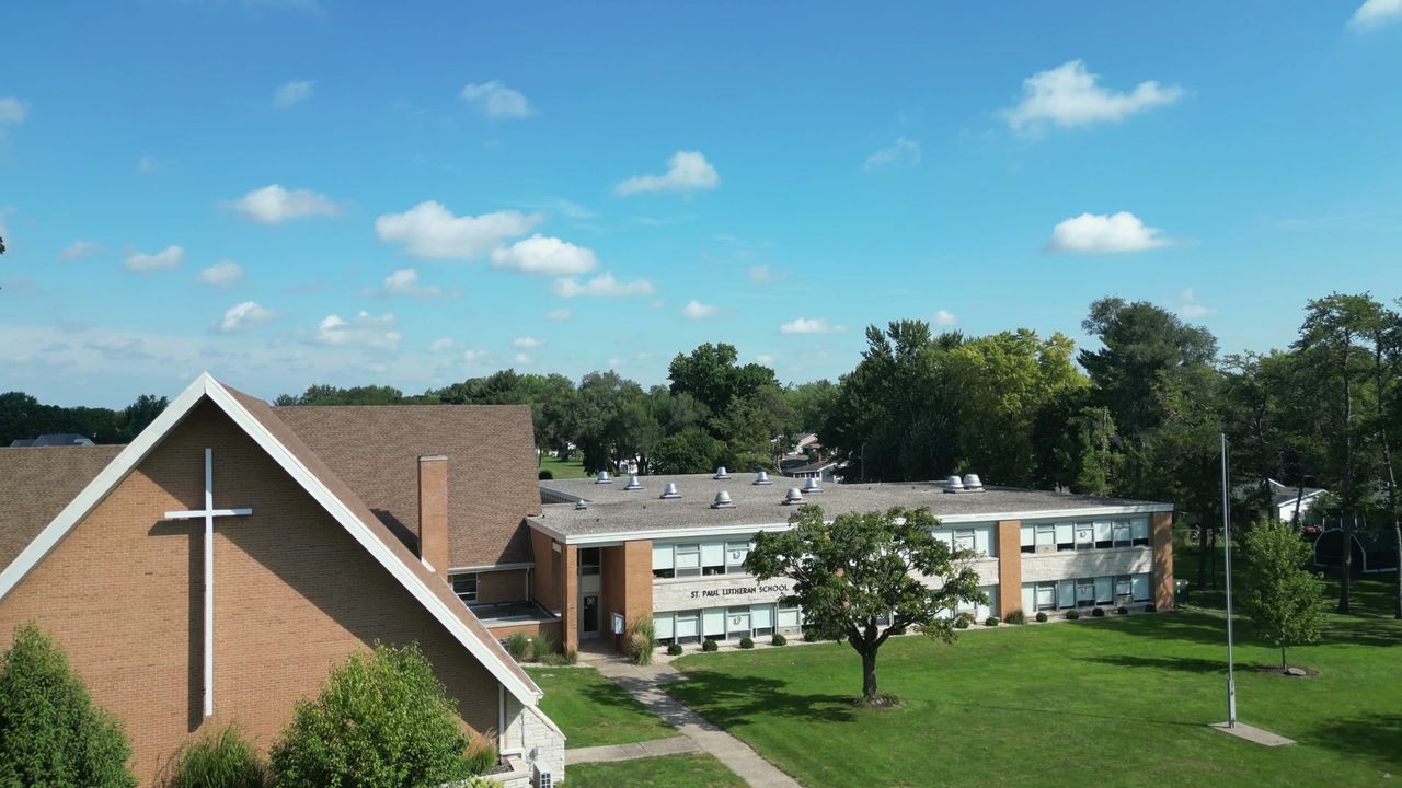 Trees, lawn, and the school buildings on the St. Paul campus.
