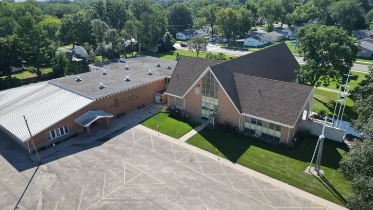 Aerial view across the St. Paul campus, with the school, church, parking, and trees.